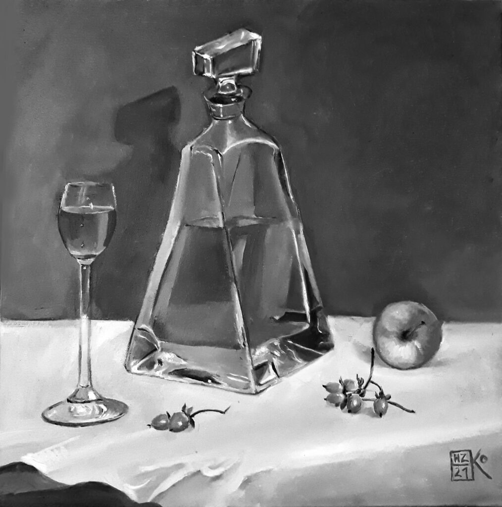 Karafka z winem, kieliszek i jabłko postawione na stole, okrytym białym obrusem