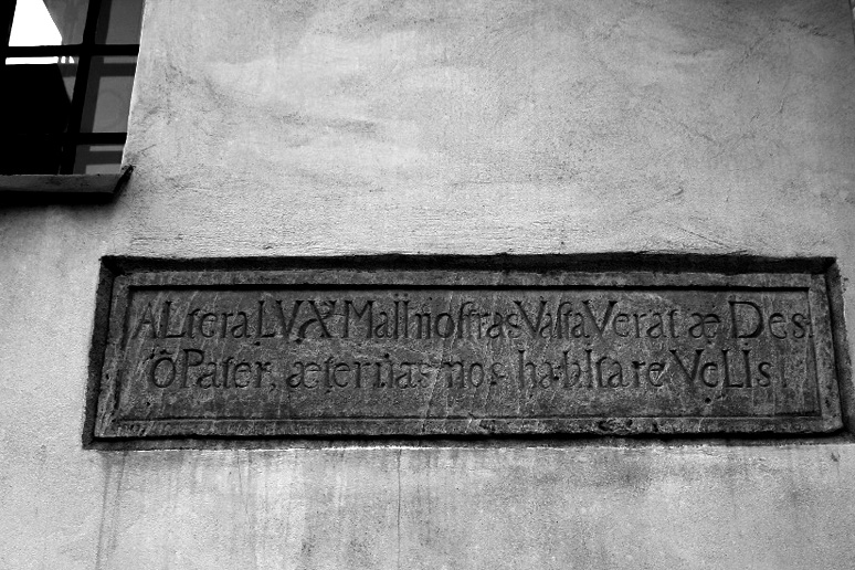 Tablica na budynku muzeum. Znajduje się na niej napis pismem gotyckim. Po niemiecku.