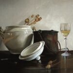 Od lewej biała waza, brązowy garnek i kieliszek wina. Stoją na brązowym stole.