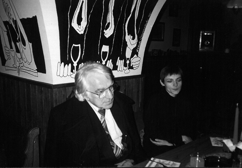 Profesor Czesław Dutka siedzi oparty w garniturze. Obok niego ubrana na czarno Maria Fraszewska. Zdjęcie jest czarno-białe.