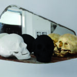 Zdjęcie trzech czasek. Od lewej biała, czarna i brązowa. Za nimi znajduje się lustro.