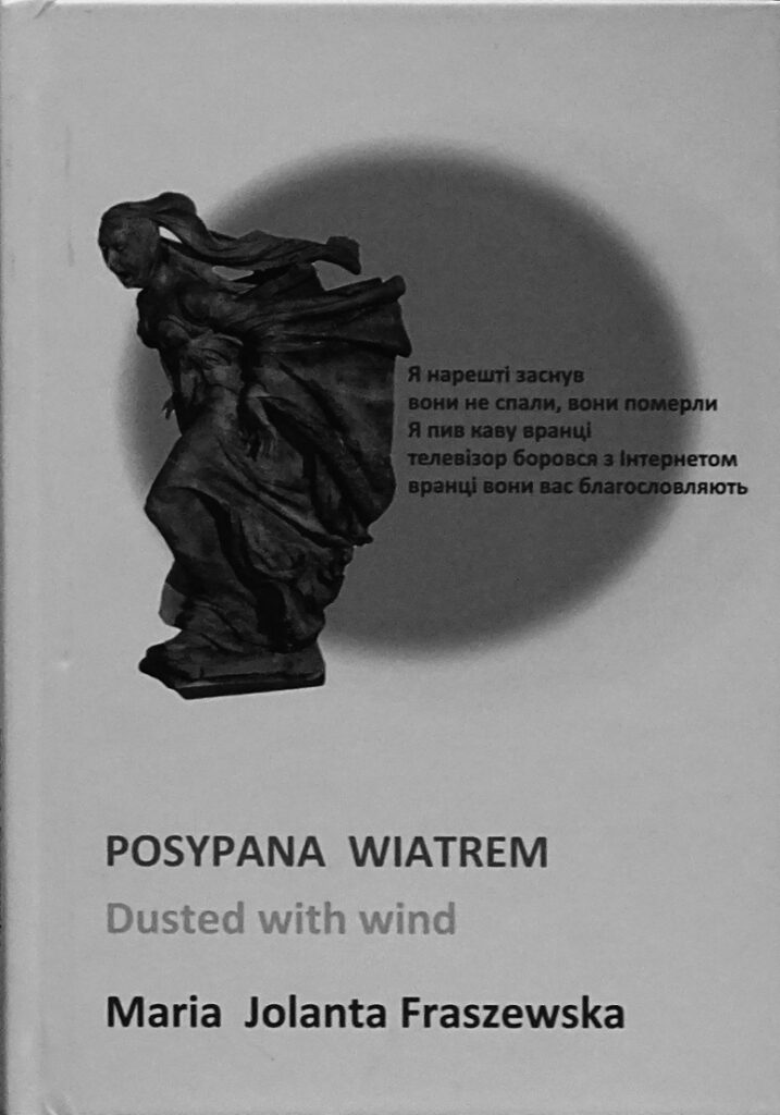 Okładka książki. Obrazek przedstawia posąg kobiety, któa zmaga się z materiałem. Pod spodem jest tytuł Posypana wiatrem