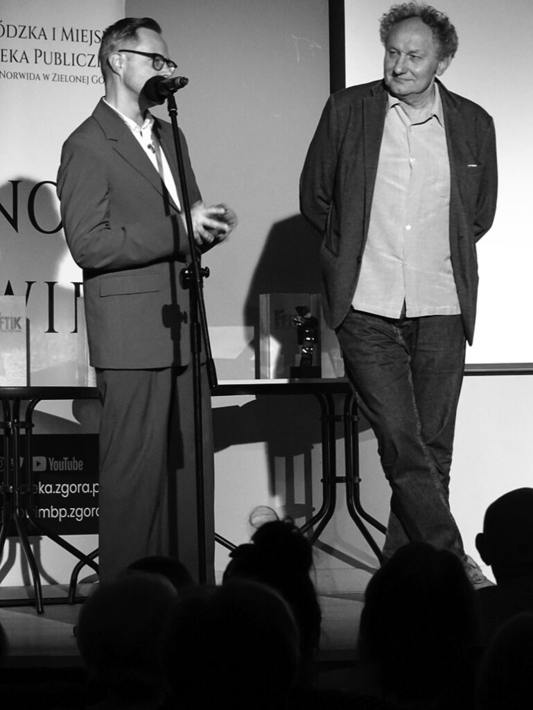 Dwóch mężczyzn stoi na scenie.